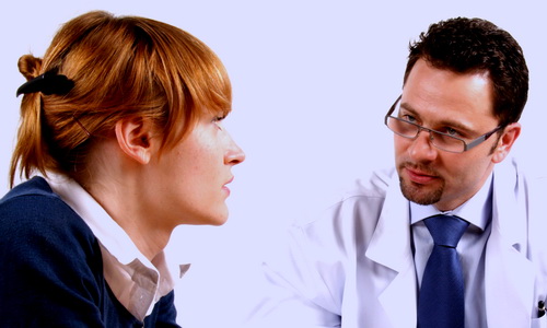 Doctor and young woman patient talking to each other.